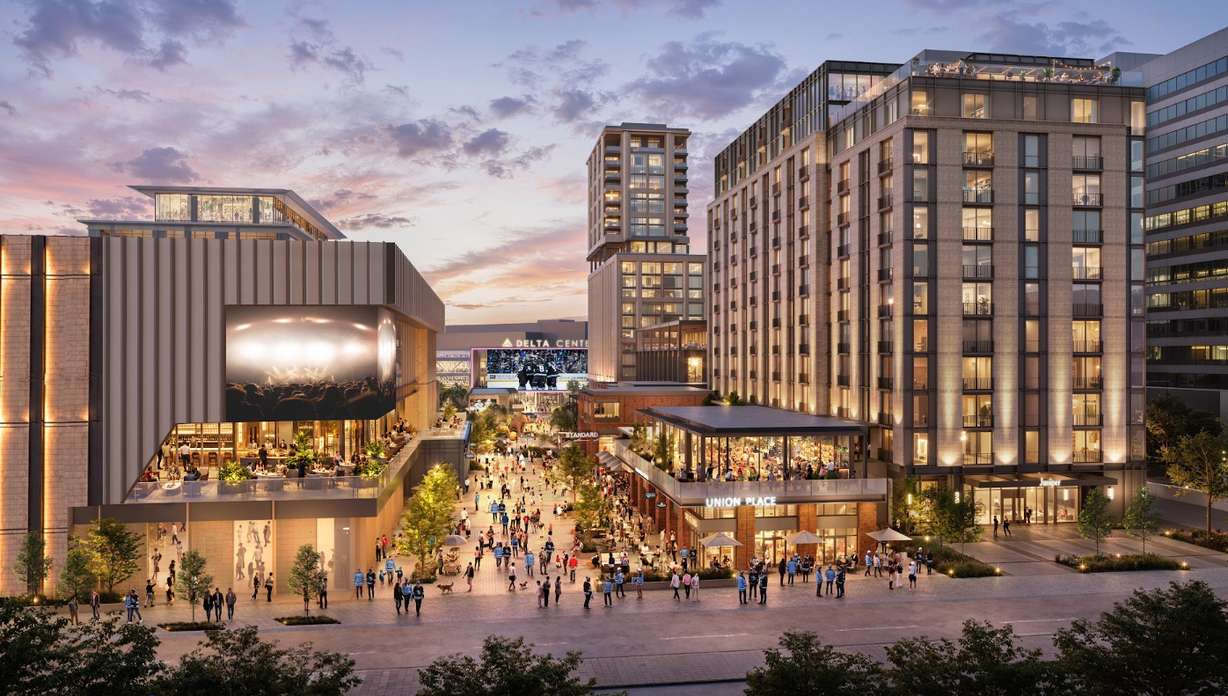 Dusk rendering of the car-free paseo leading to the Delta Center, lined with a hotel, residential towers and a concert venue