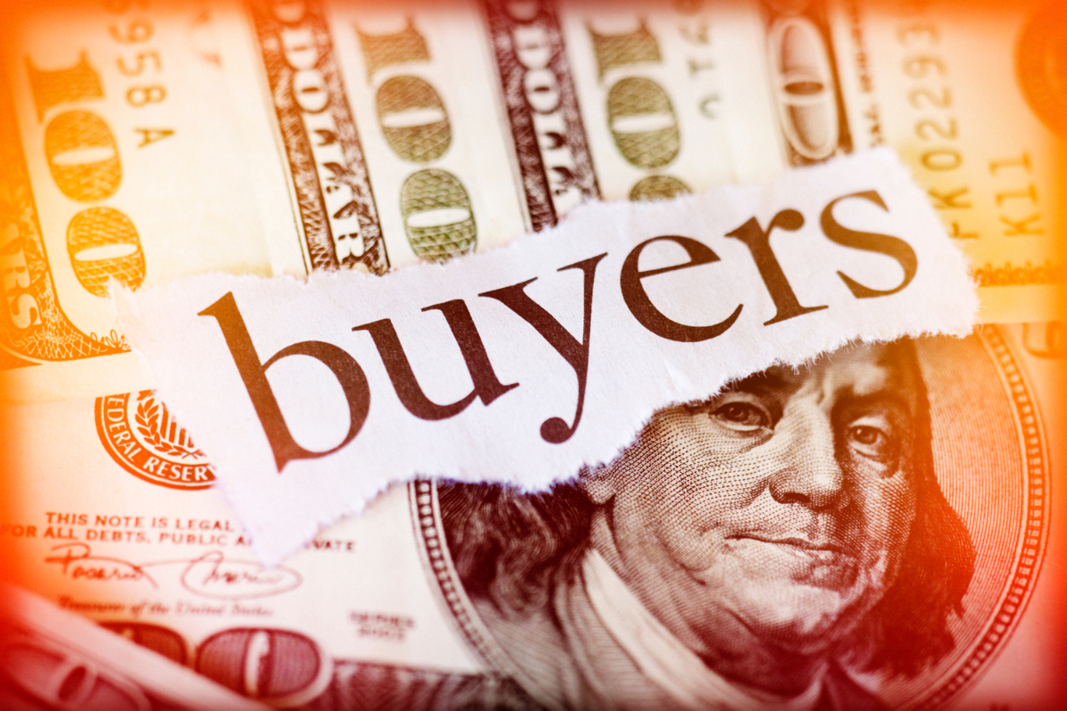 The word buyers on torn paper over U.S. hundred-dollar bills, symbolizing real estate costs and homebuyer demand in Utah 2025.