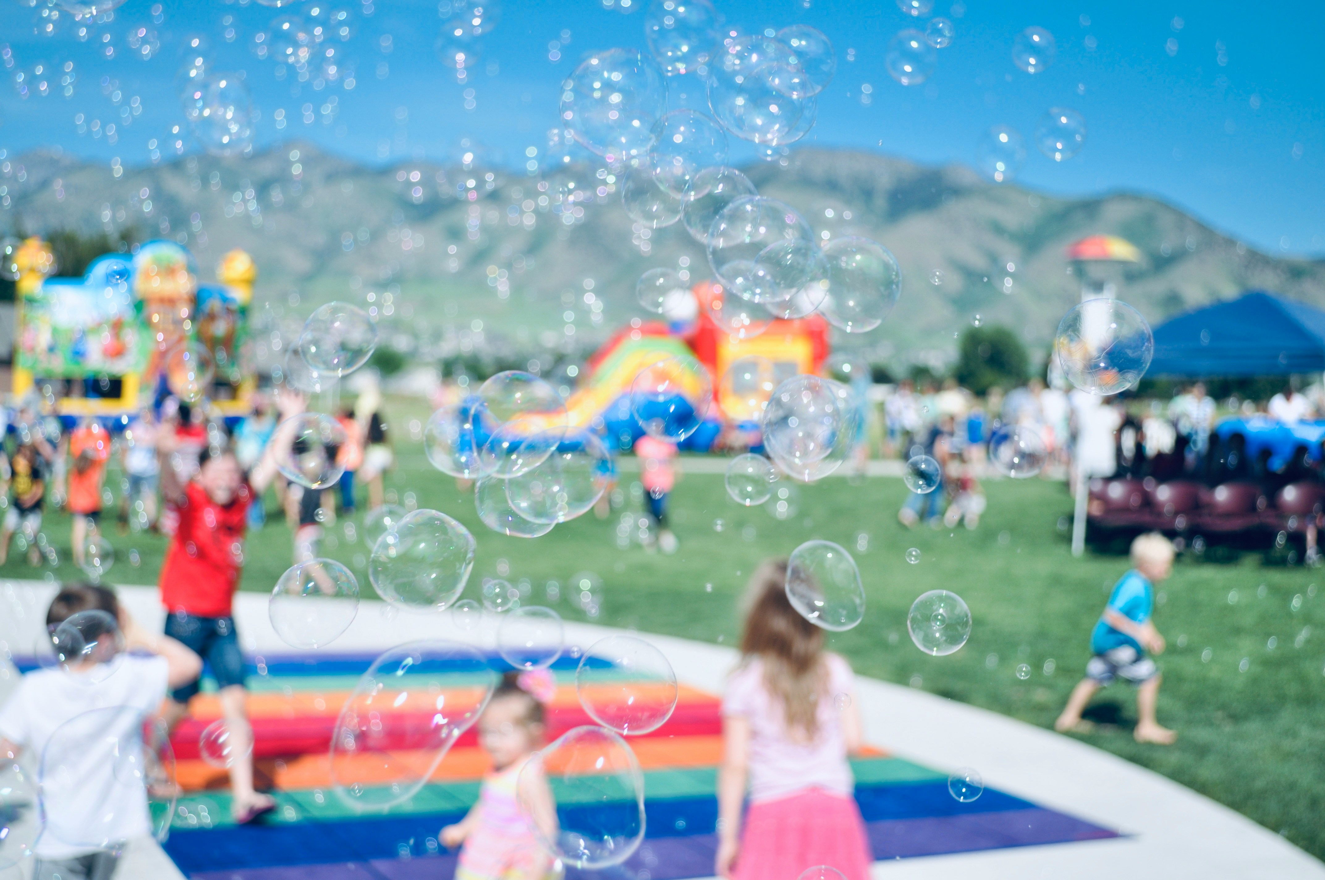 Crowd enjoying a summer parade at a Utah city festival with fireworks and mountain views in the background.
