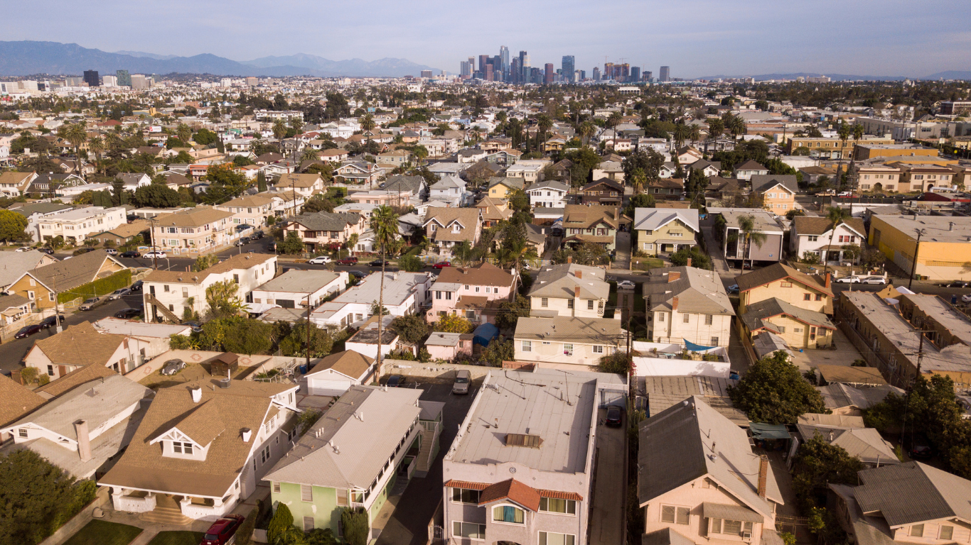 Aerial view of Los Angeles residential neighborhood with downtown skyline in the background, showcasing urban housing market and real estate opportunities in Southern California.