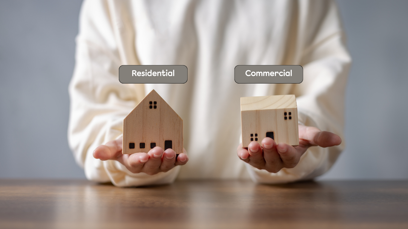 Comparison of residential vs commercial real estate — person holding two wooden houses labeled “Residential” and “Commercial,” representing how properties are valued differently in real estate investing.