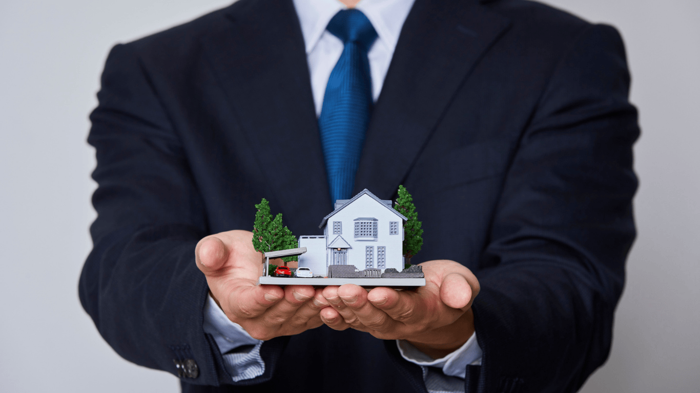 Real estate agent in a suit holding a miniature house model symbolizing property management, home selling, and investment opportunities in Los Angeles.