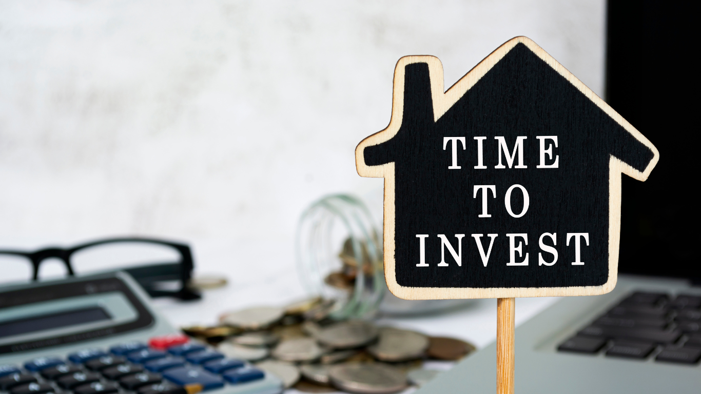 Chalkboard house sign reading “TIME TO INVEST,” emphasizing property investment, market opportunity, and real estate strategy.