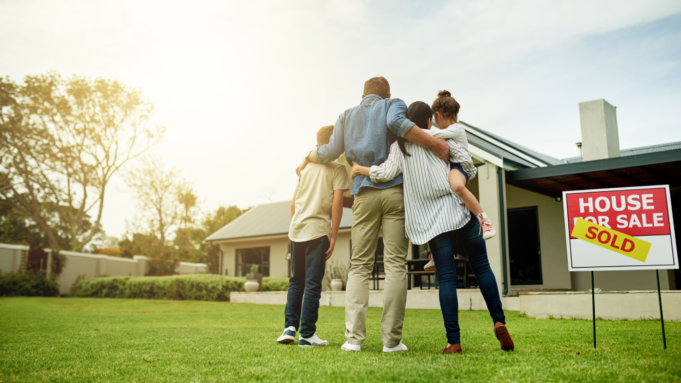 A family standing in front of their sold house