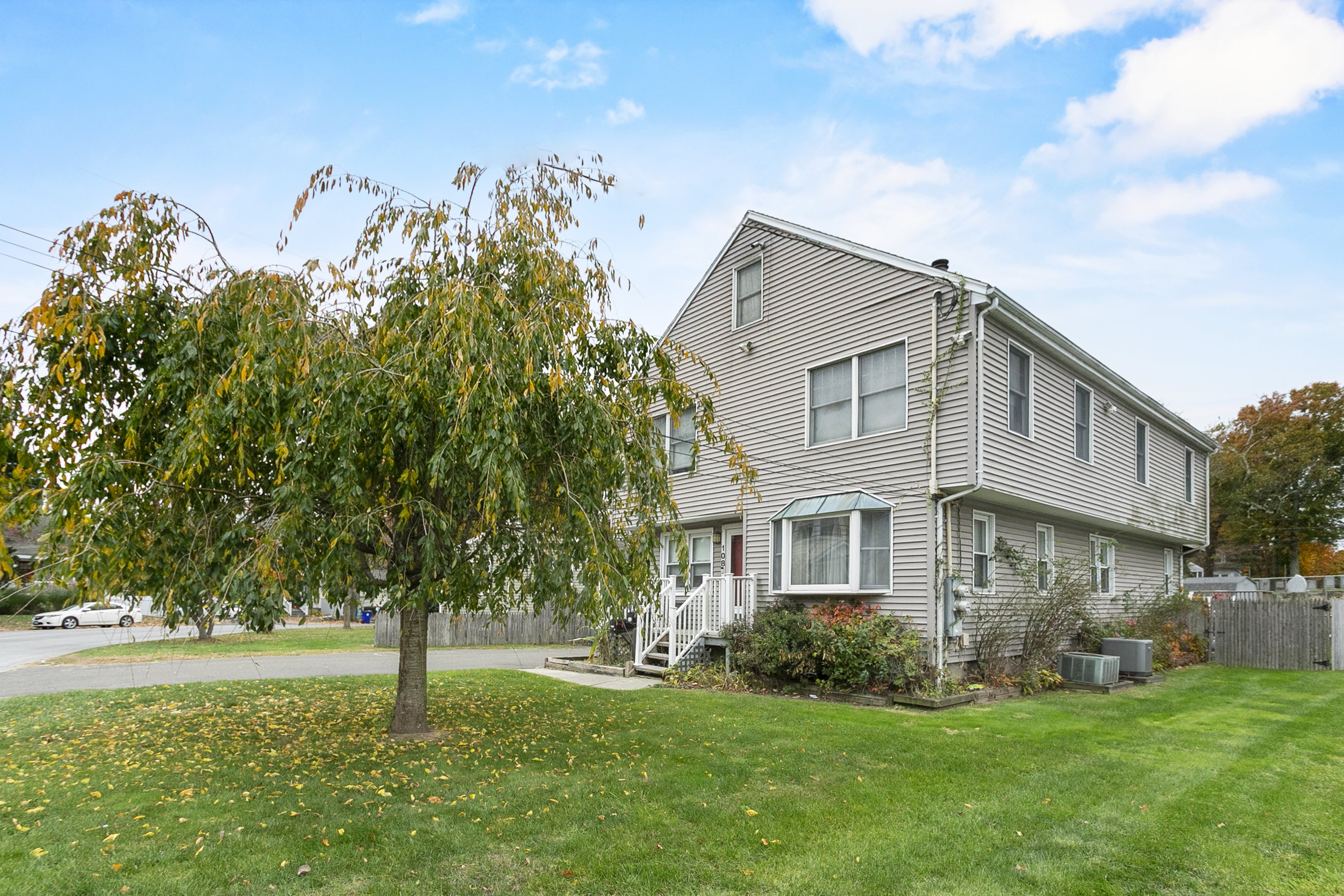 Two-family home with mature fruit tree and lawn at 108 Roseville Street, Fairfield CT