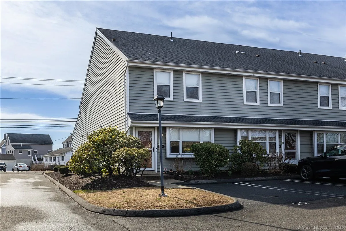 Gray end-unit townhouse with landscaping and parking in the Silver Sands community, Milford CT