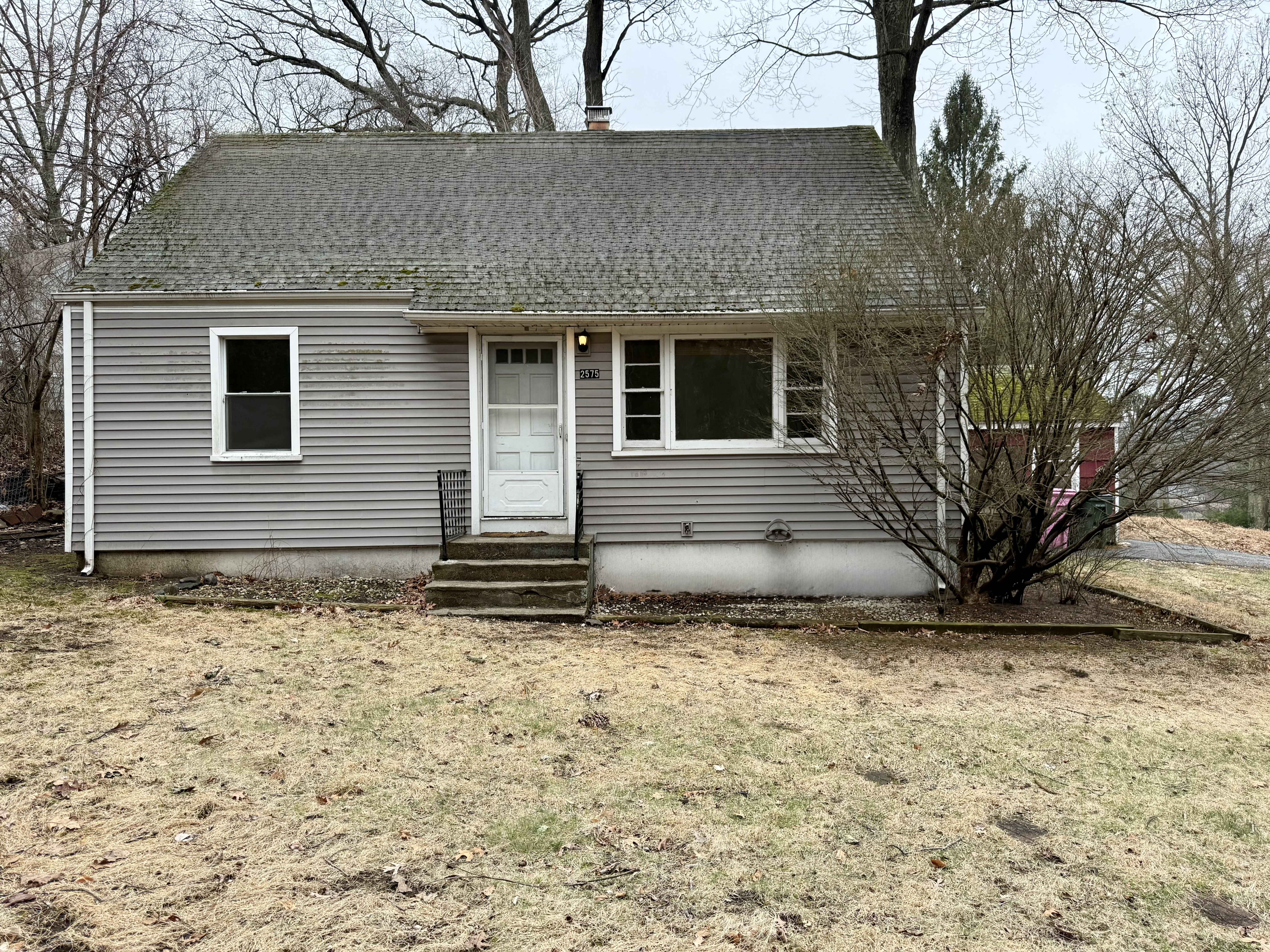 Gray Cape-style home with a front dormer at 2575 Black Rock Turnpike, Fairfield CT, on an early spring day