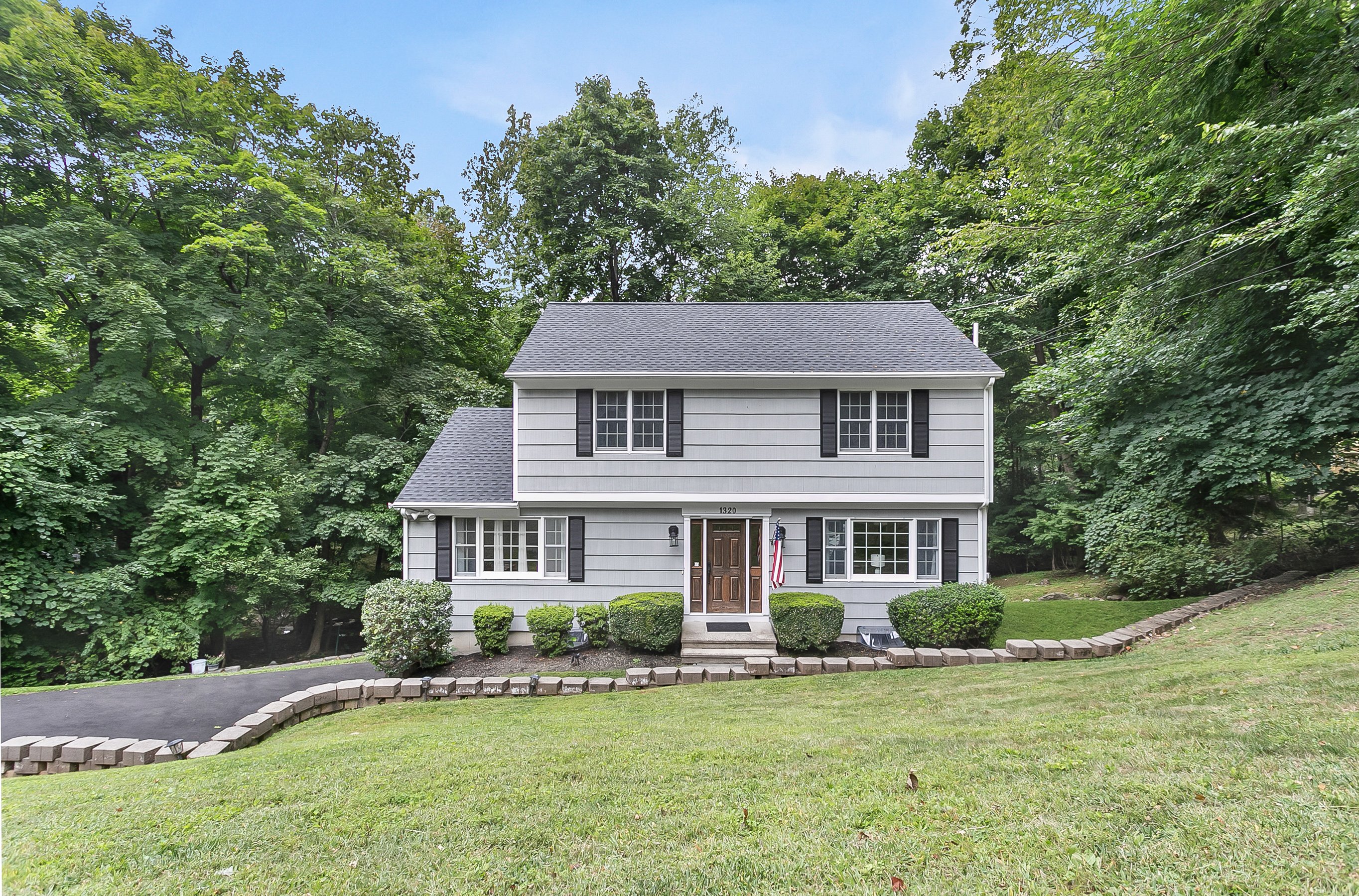 Gray Colonial home with white trim and landscaped front yard at 1320 Merritt Street, Fairfield CT