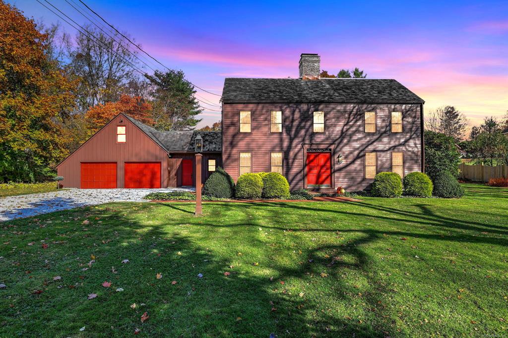 58 Manor Hill Road, Stratford CT — saltbox colonial with red garage doors at dusk