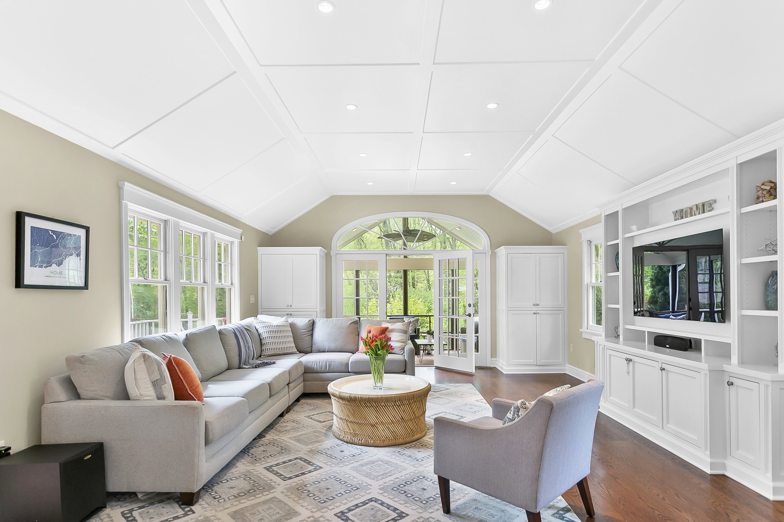 Vaulted family room with a wall of windows, built-in cabinetry and neutral seating at 180 Merwins Lane, Fairfield CT