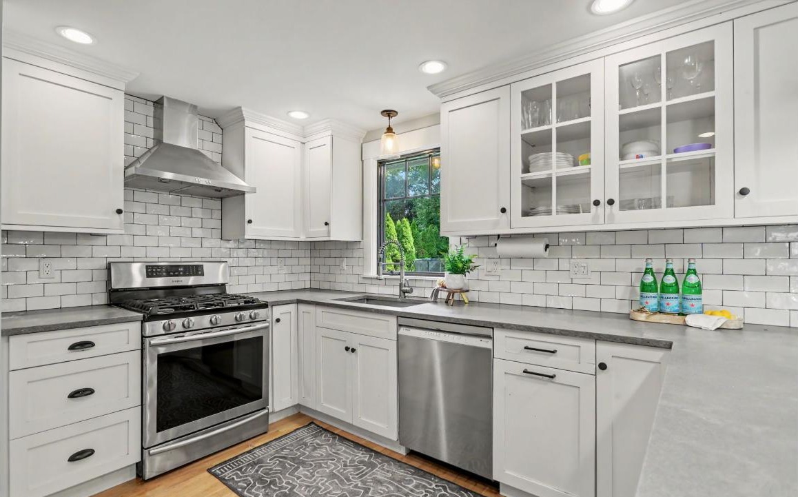 Updated kitchen at 214 Alberta St, Fairfield CT with white shaker cabinetry, subway tile backsplash, and stainless appliances
