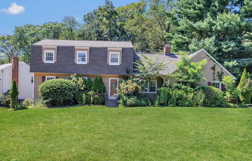 Dutch Colonial with dormers and mature landscaping near Lake Mohegan in Fairfield, CT