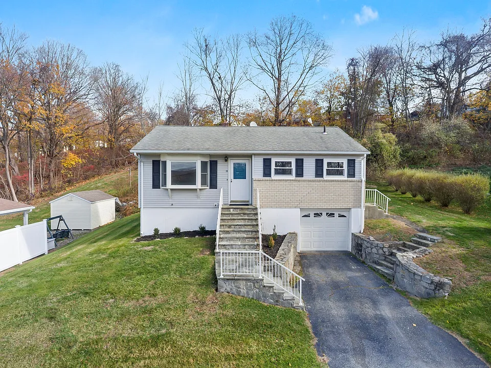 Raised ranch with attached garage and hillside backdrop at 23 Berkshire Road, Ansonia CT