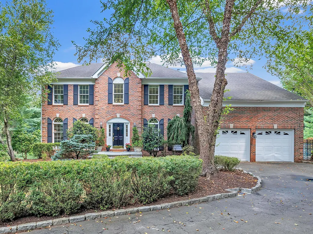 Brick Colonial with attached two-car garage and mature trees at 159 Blue Bell Lane