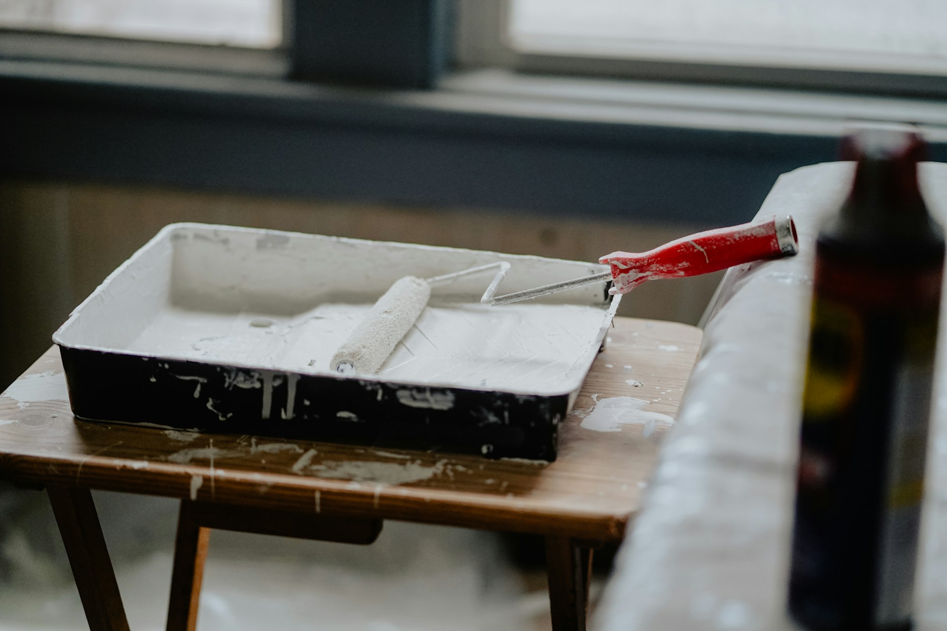 Paint tray and roller on a drop cloth during a home renovation