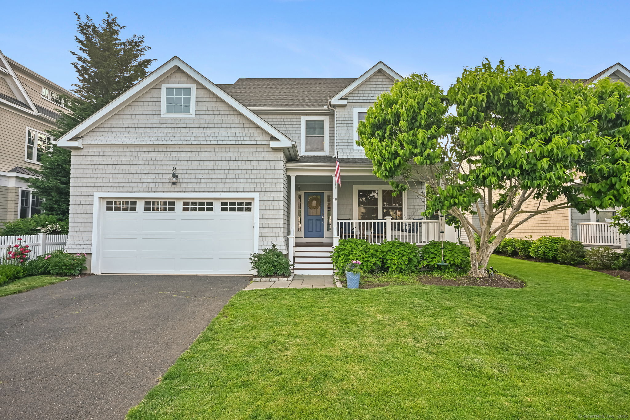 Shingled home with a two-car garage, front porch and landscaped lawn at 18 Cummings Avenue, Fairfield CT, recently sold
