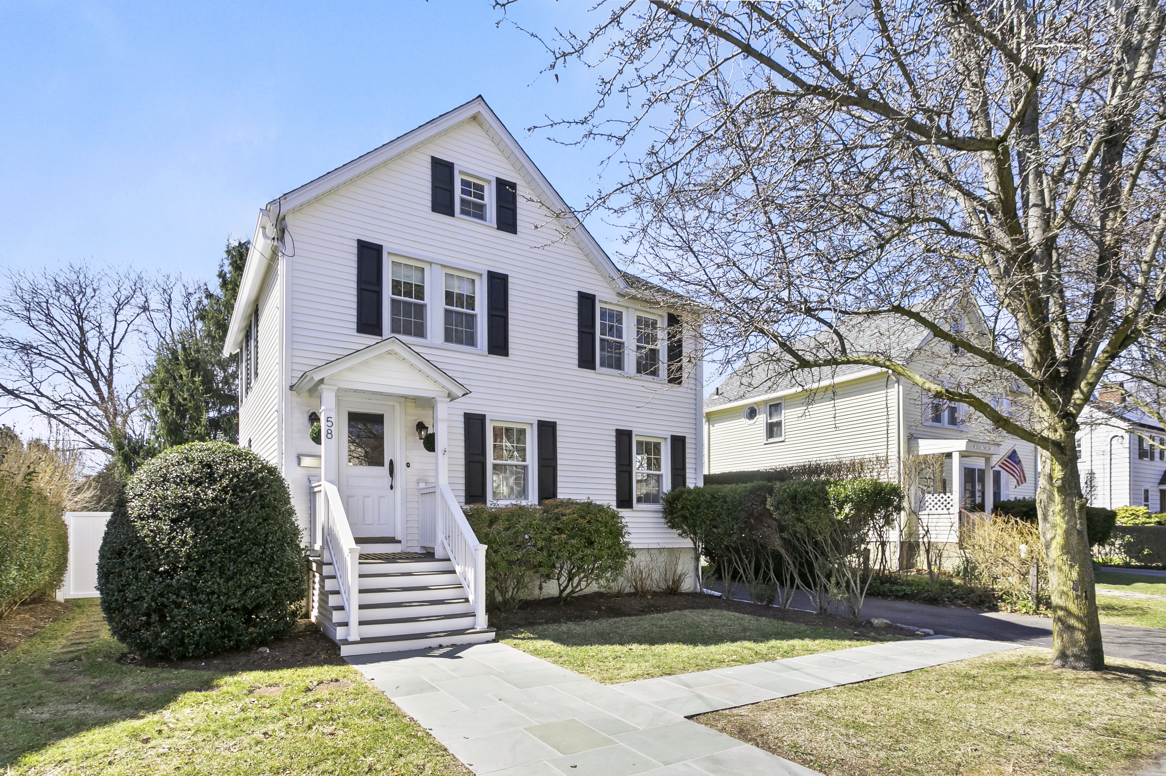 White colonial home with black shutters and a front porch at 58 Smith Street, Fairfield CT