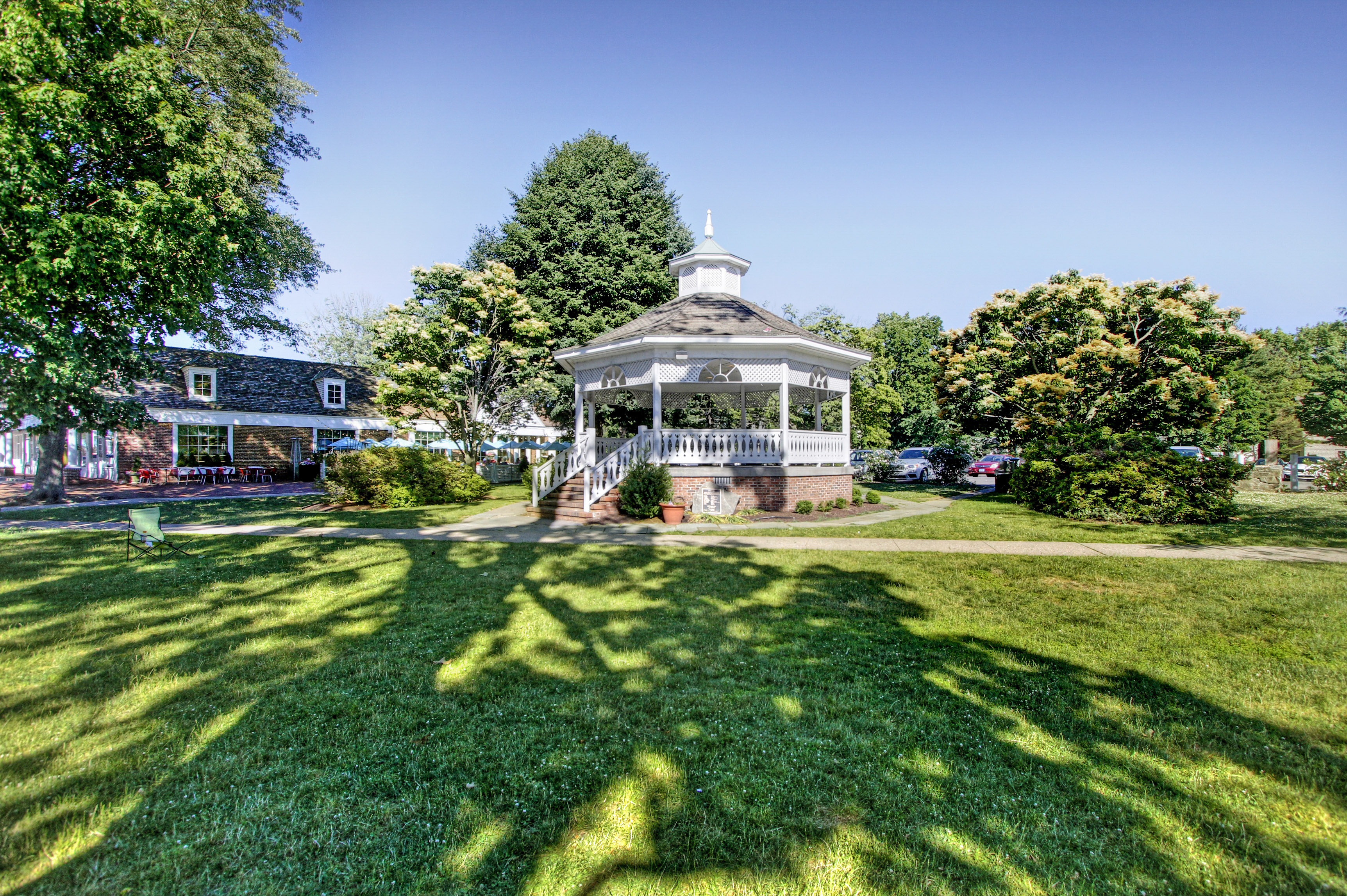 White gazebo on a village green surrounded by mature trees in Fairfield, CT