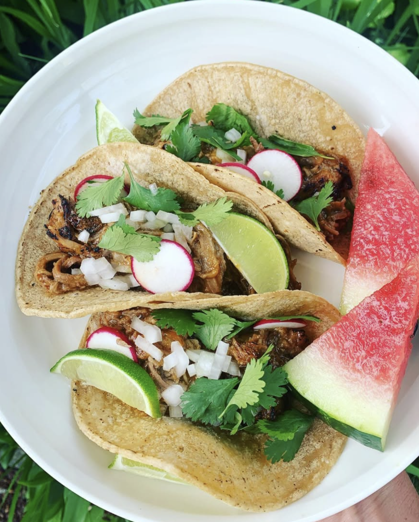 Street tacos with radish, cilantro and lime beside watermelon slices