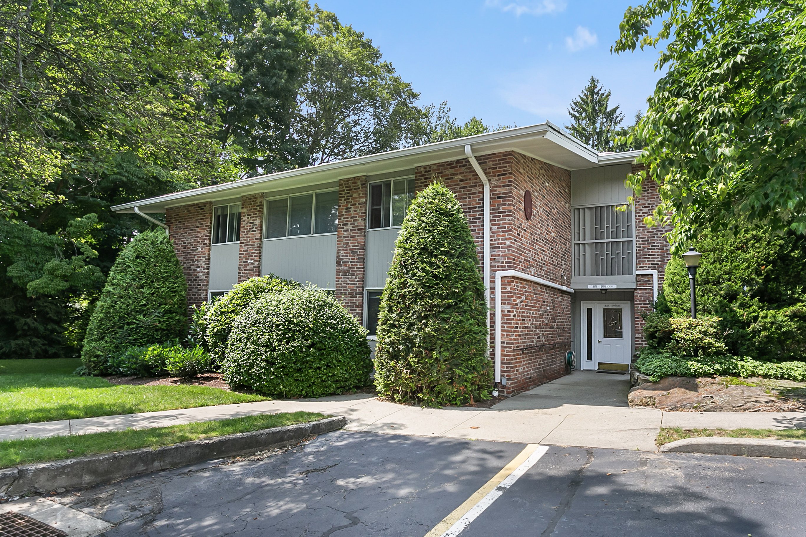 Exterior of the Southport Woods Drive condominium community in Fairfield County, CT, framed by mature trees