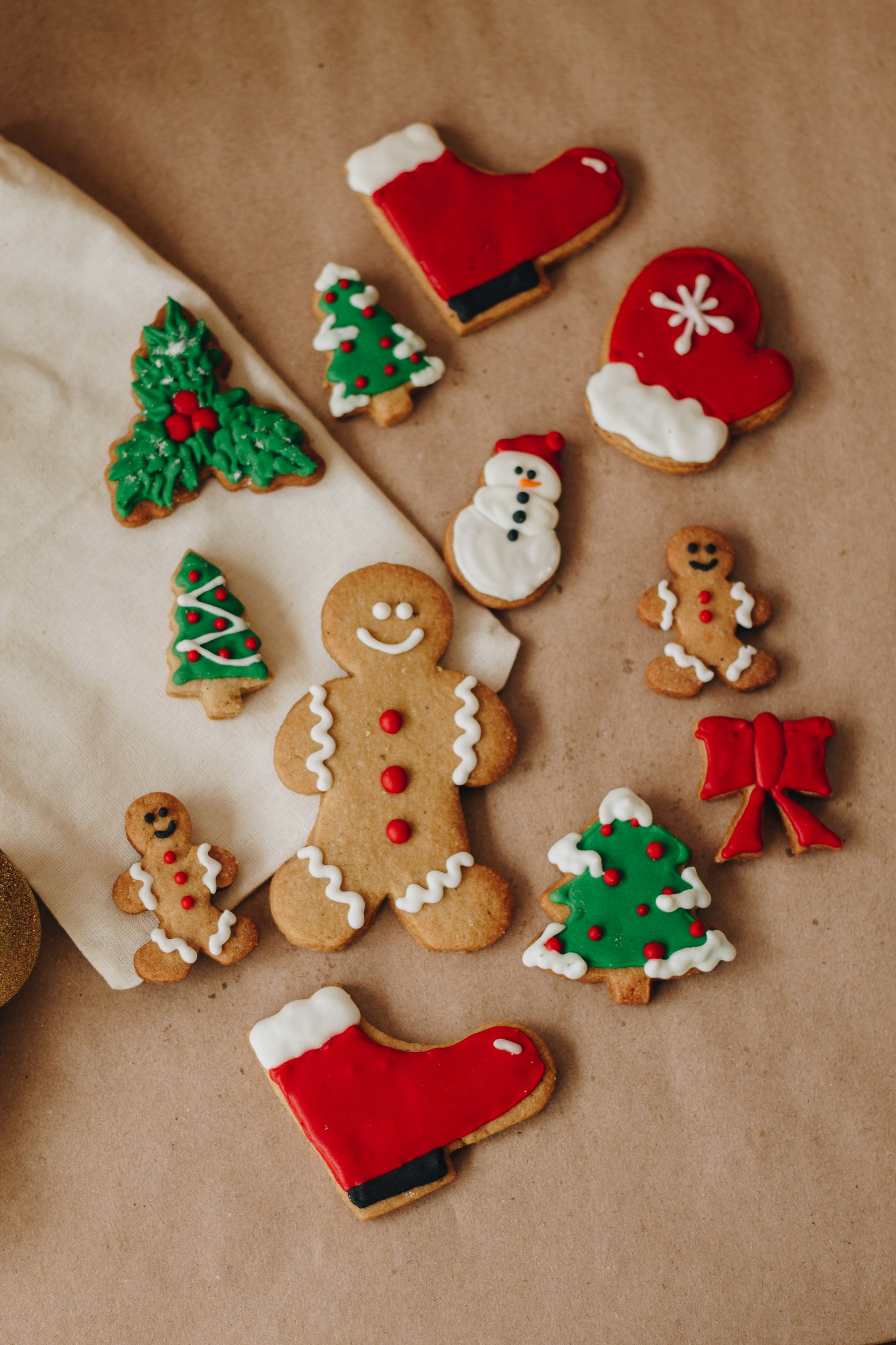Decorated gingerbread men, snowmen and Christmas tree cookies on parchment