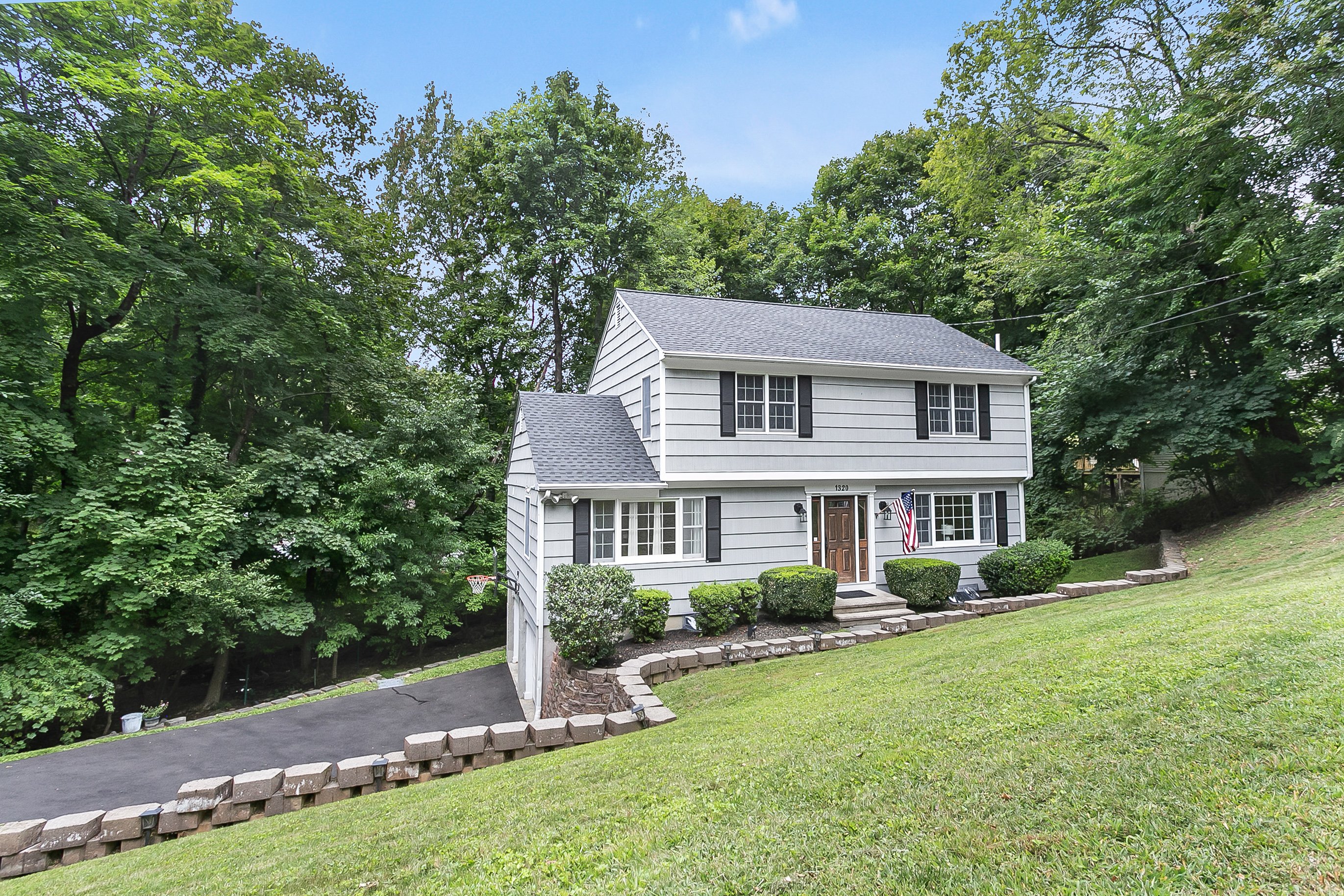 Gray Colonial with white trim and a landscaped front yard at 1320 Merritt Street, Fairfield CT, recently sold