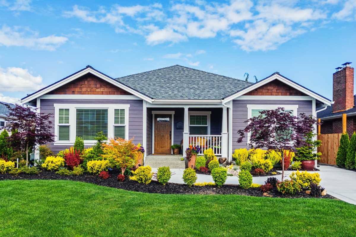 Single-story ranch home with a covered porch and colorful landscaped front garden in Fairfield County CT