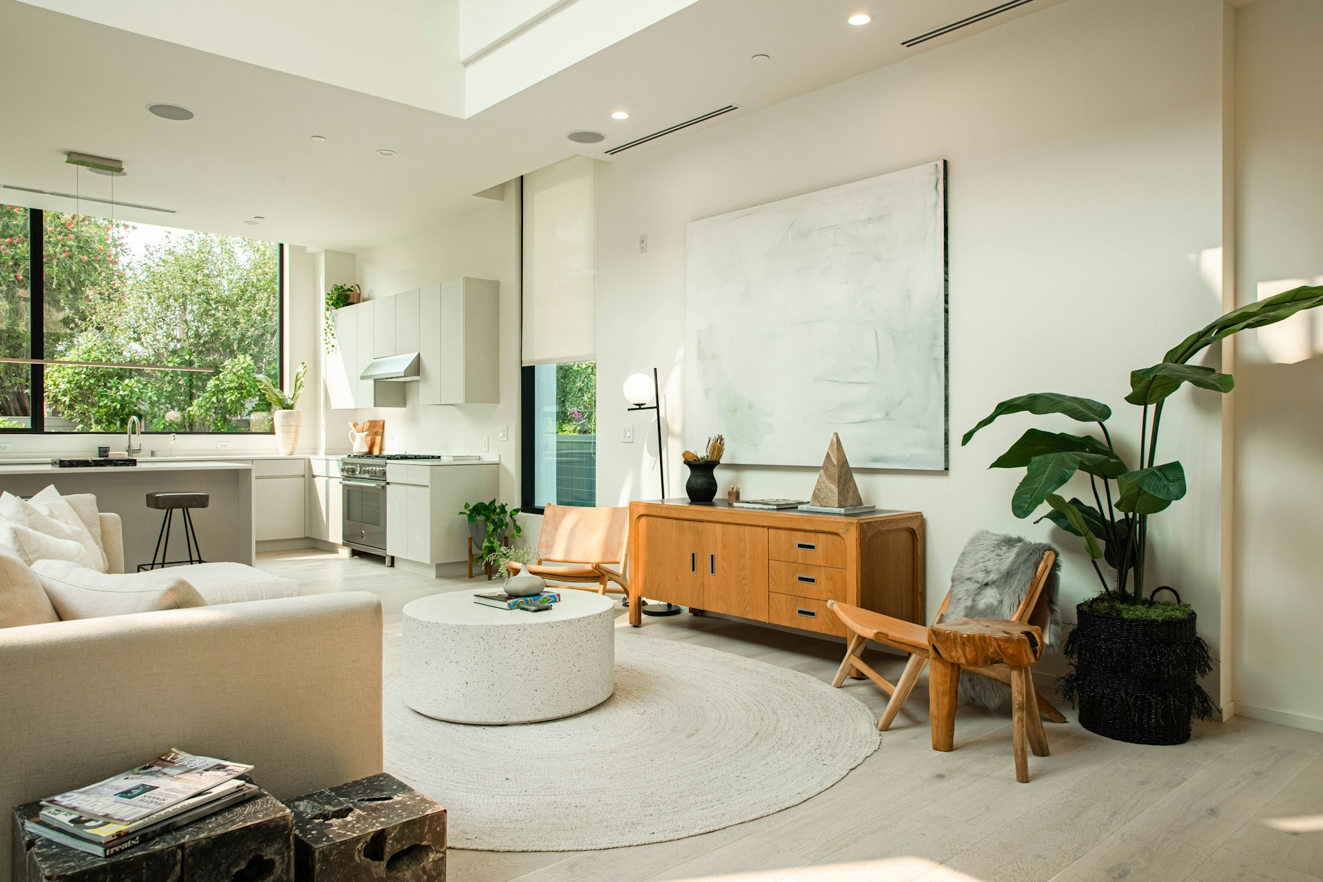 Bright living room with plants, low wood credenza and large windows