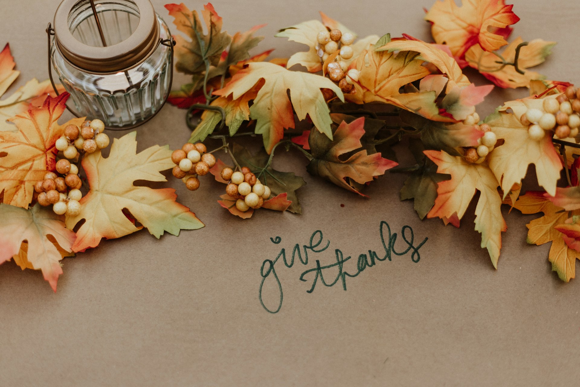 Autumn leaves and berries around a handwritten “give thanks” message