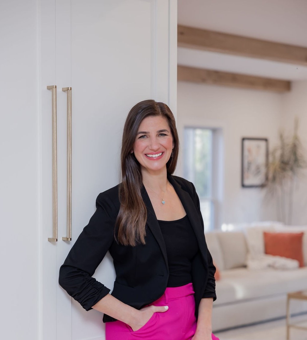 Shoshana Snyder in a black blazer standing in a bright Fairfield County living room