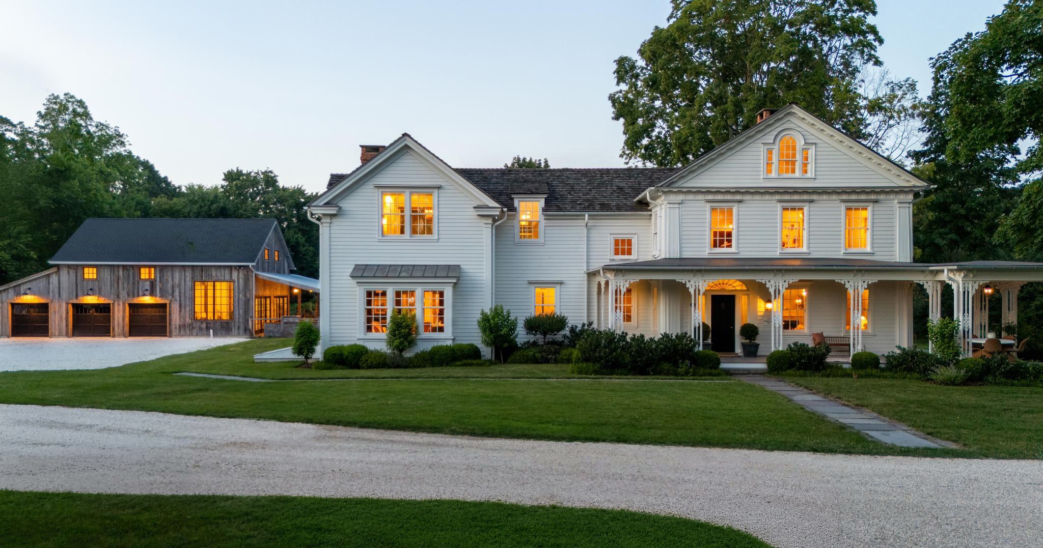 Front exterior of 98 Banks Place, an 1830 Greek Revival estate in Southport, CT at dusk