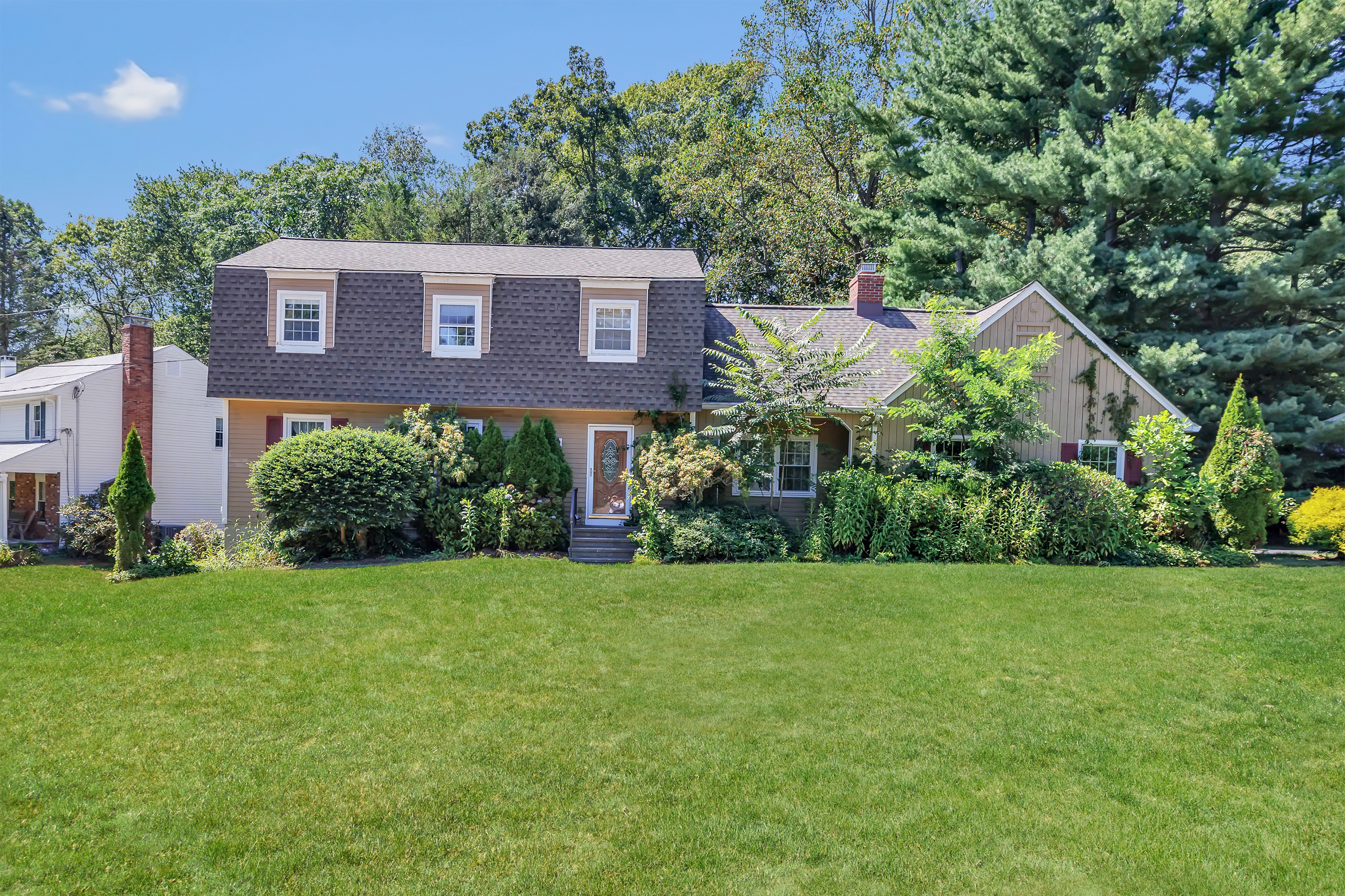 Front exterior of 821 Cascade Drive, a Dutch Colonial in Fairfield, CT
