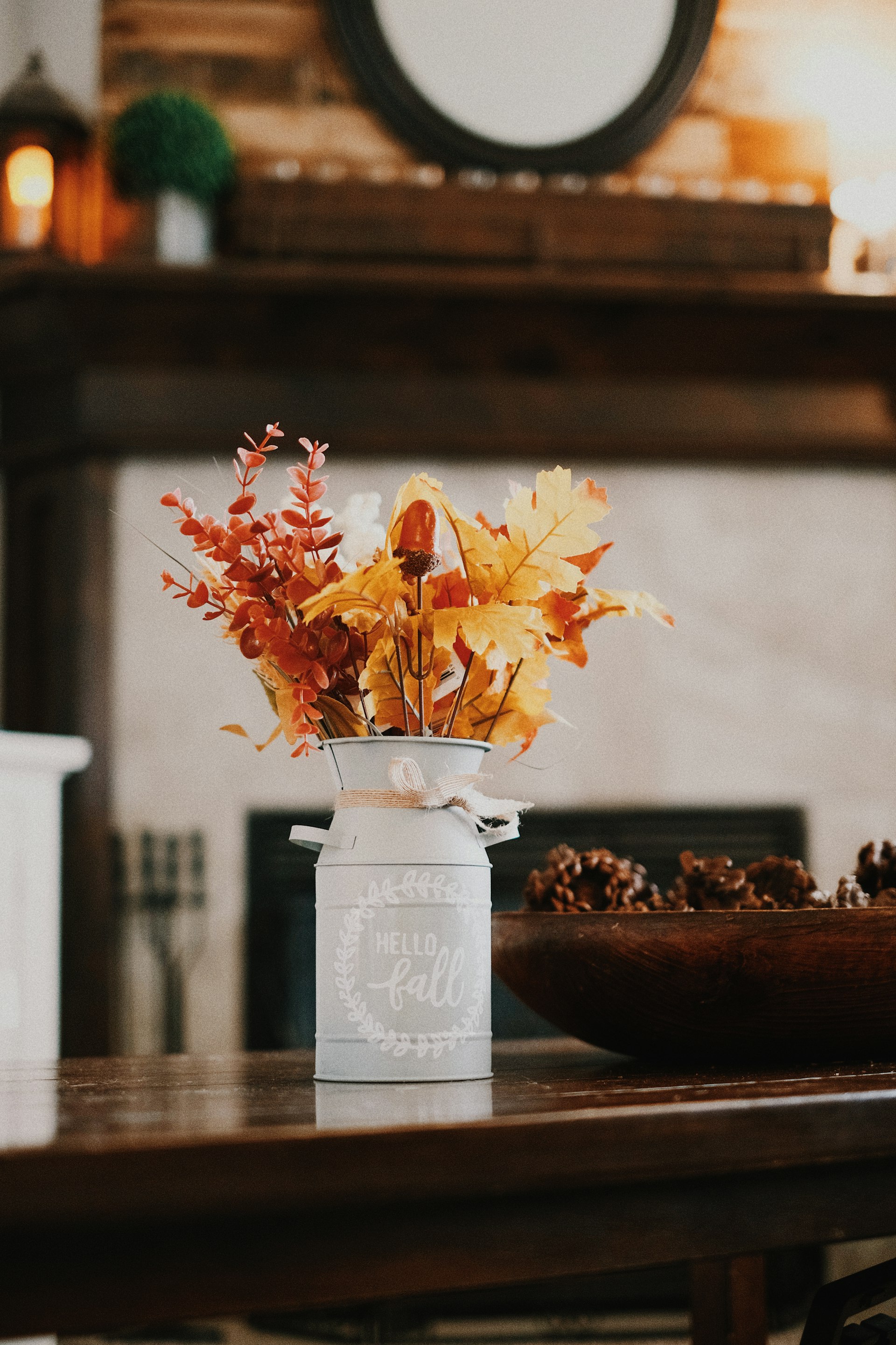 Vase of autumn leaves and dried flowers on a table in a warm interior
