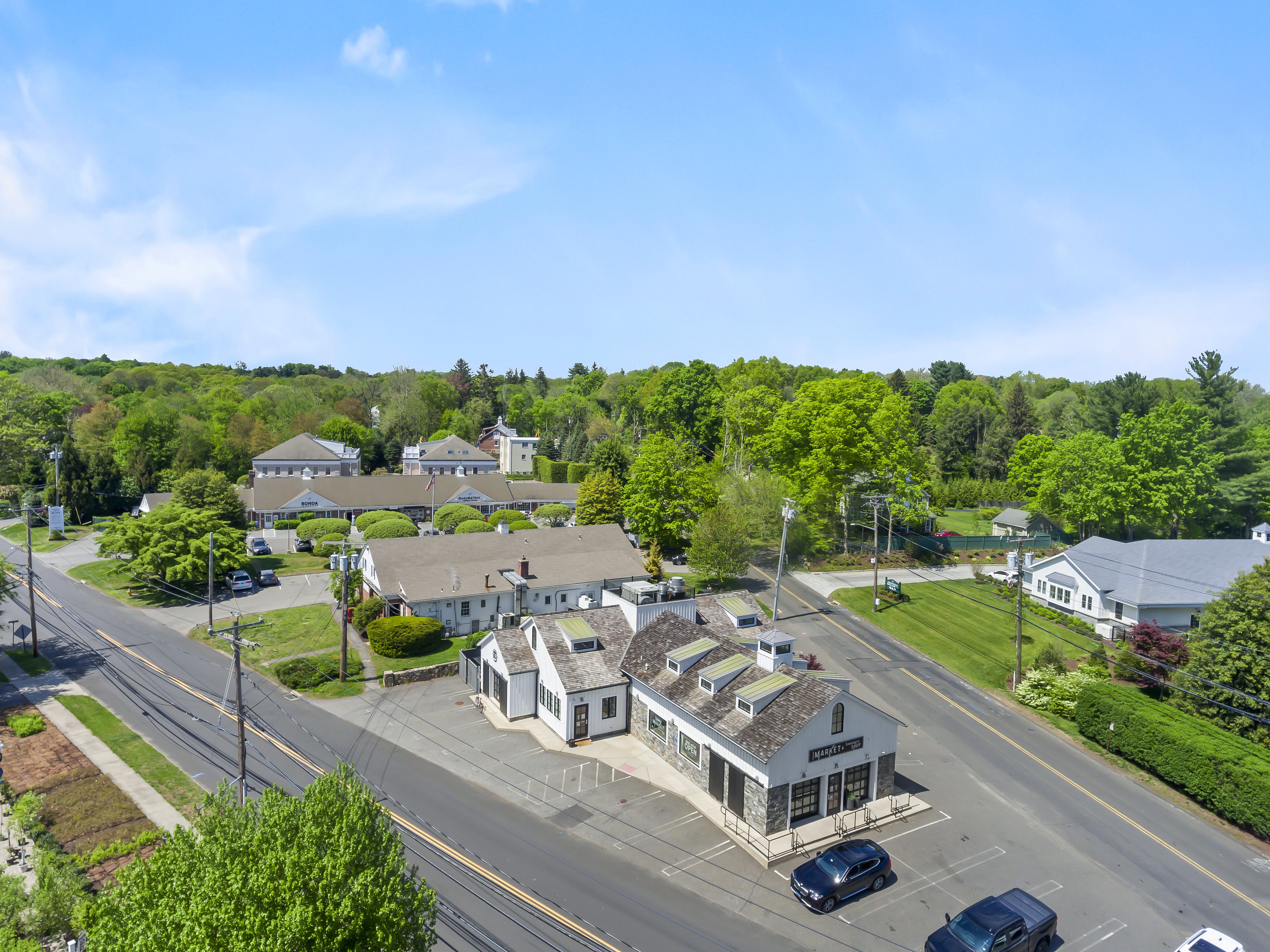 Aerial view of the Greenfield Hill village crossroads in Fairfield CT, with white clapboard buildings and mature trees
