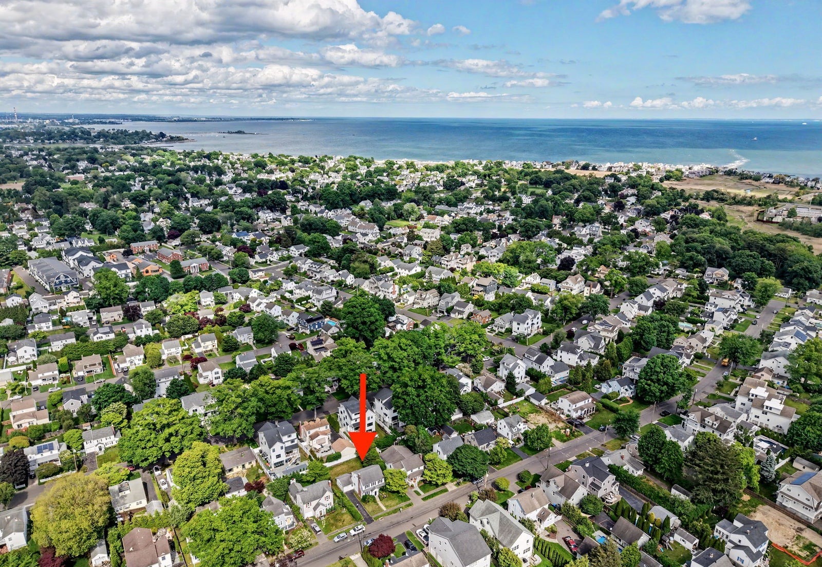 Aerial view of a Fairfield neighborhood of tree-lined streets with Long Island Sound and the beach in the background