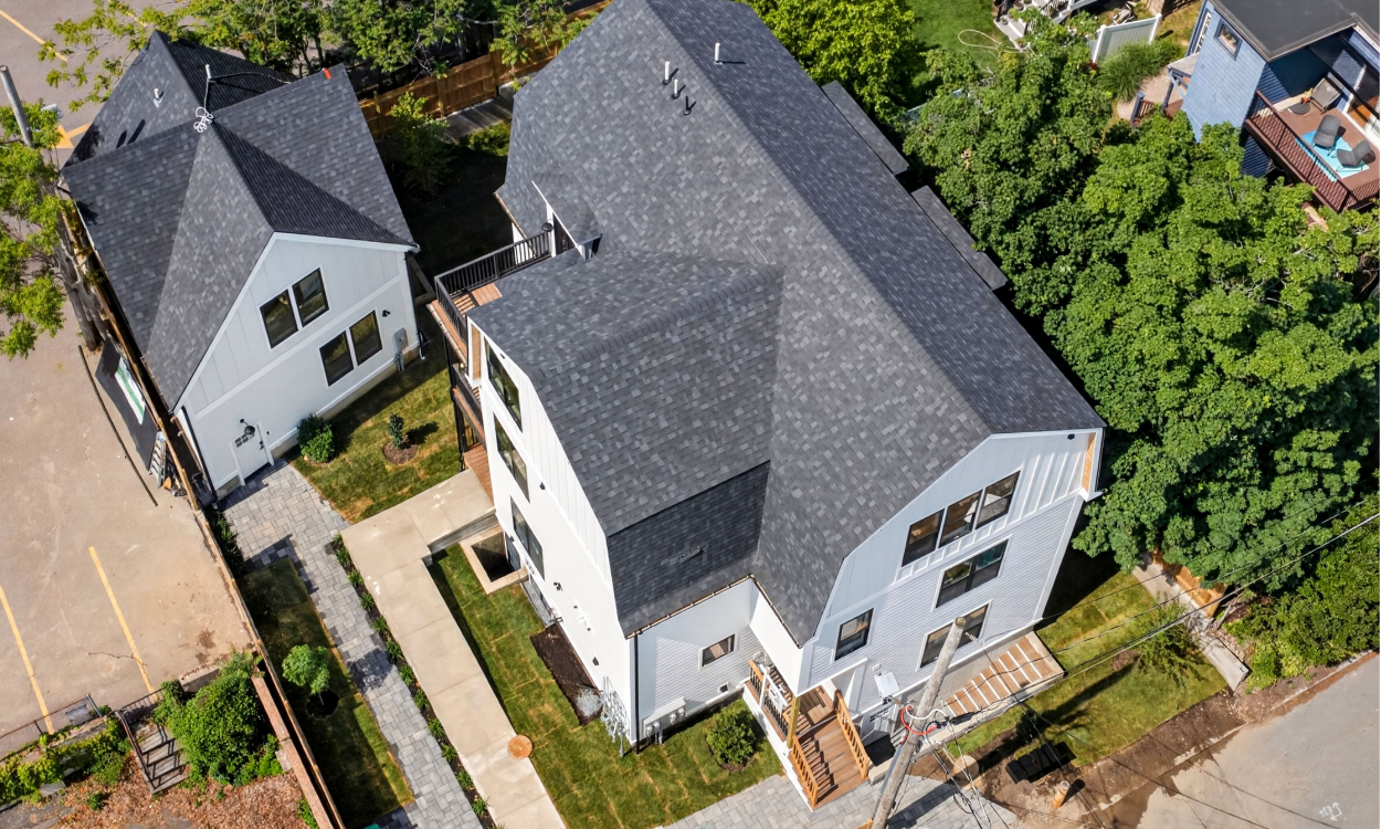 Detached backyard cottage behind a larger residential property in Spring Hill Somerville Massachusetts