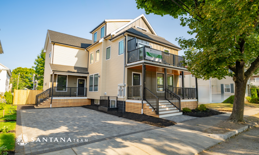 Newly converted two-unit condo in Arlington, MA, featuring separate entrances, private porches, balcony, paved driveway, and updated exterior siding.