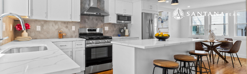 Bright renovated kitchen with white shaker cabinets, marble-style countertops, stainless steel appliances, and island seating, staged by the Santana Team at 44 Greenhalge St in Medford