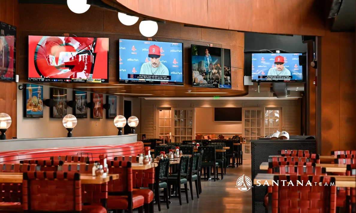 Interior of The Establishment restaurant in Medford, MA with booths, tables, and TVs, a family-friendly dining spot featured in Santana Team’s local guide.