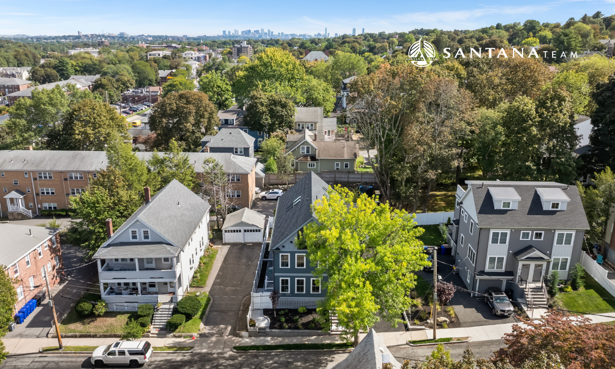 Arlington MA neighborhood with mix of single-family homes and multi-family housing with Boston skyline in the distance