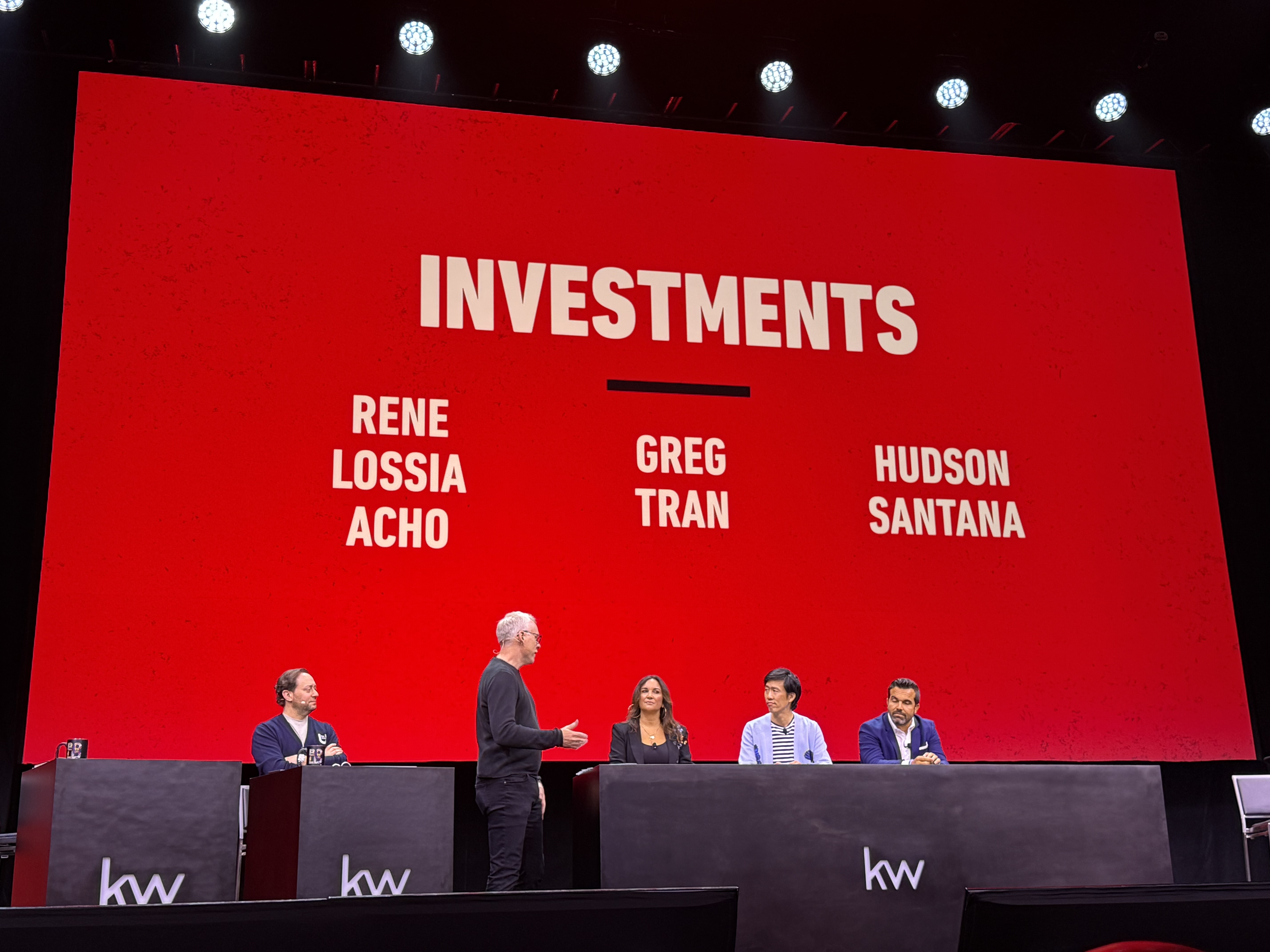 Wide view of the KW Mega Agent Camp 2025 main stage with the panel under a large red backdrop