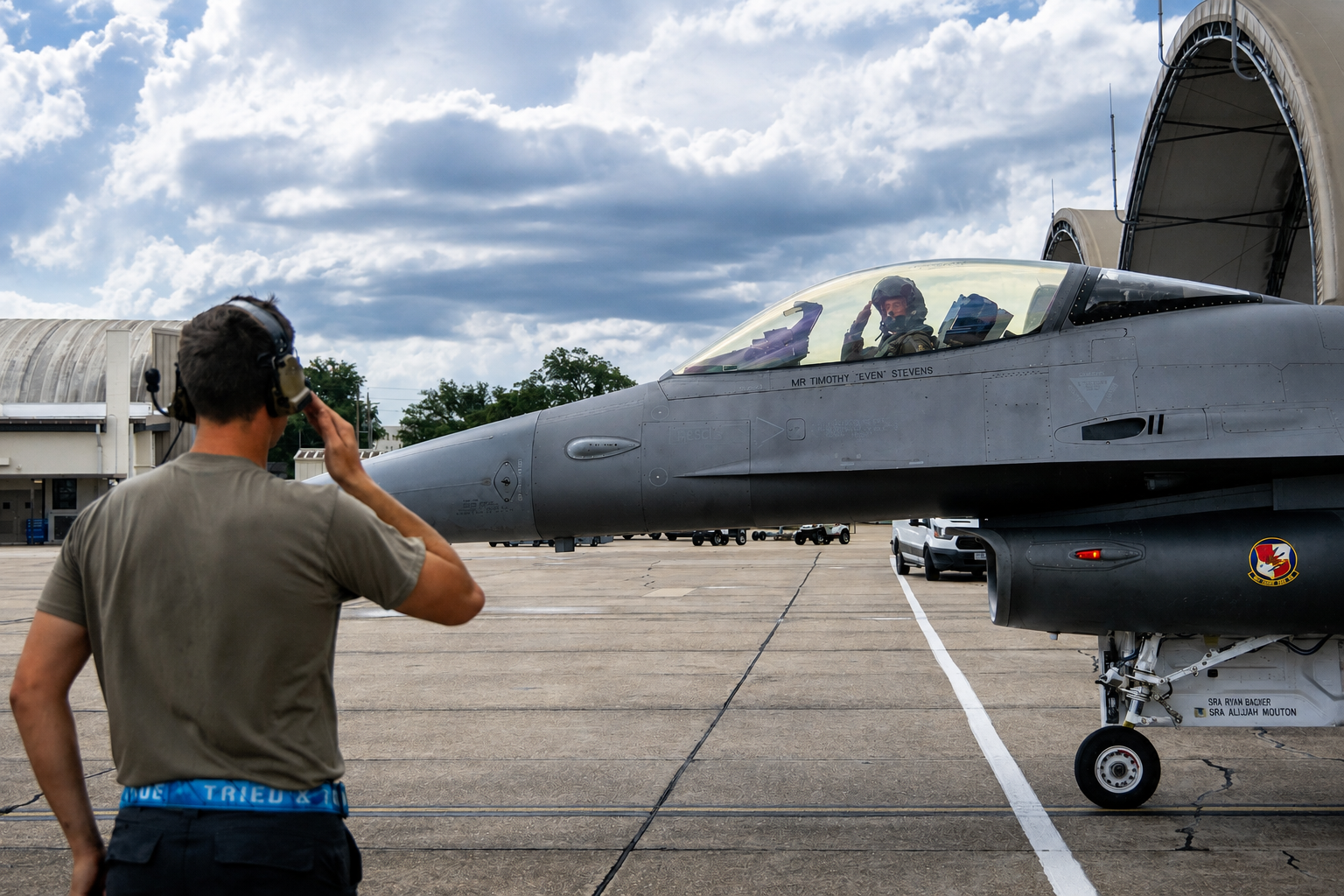 Military crew member standing beside a fighter jet with a pilot in the cockpit - Eglin Air force Base