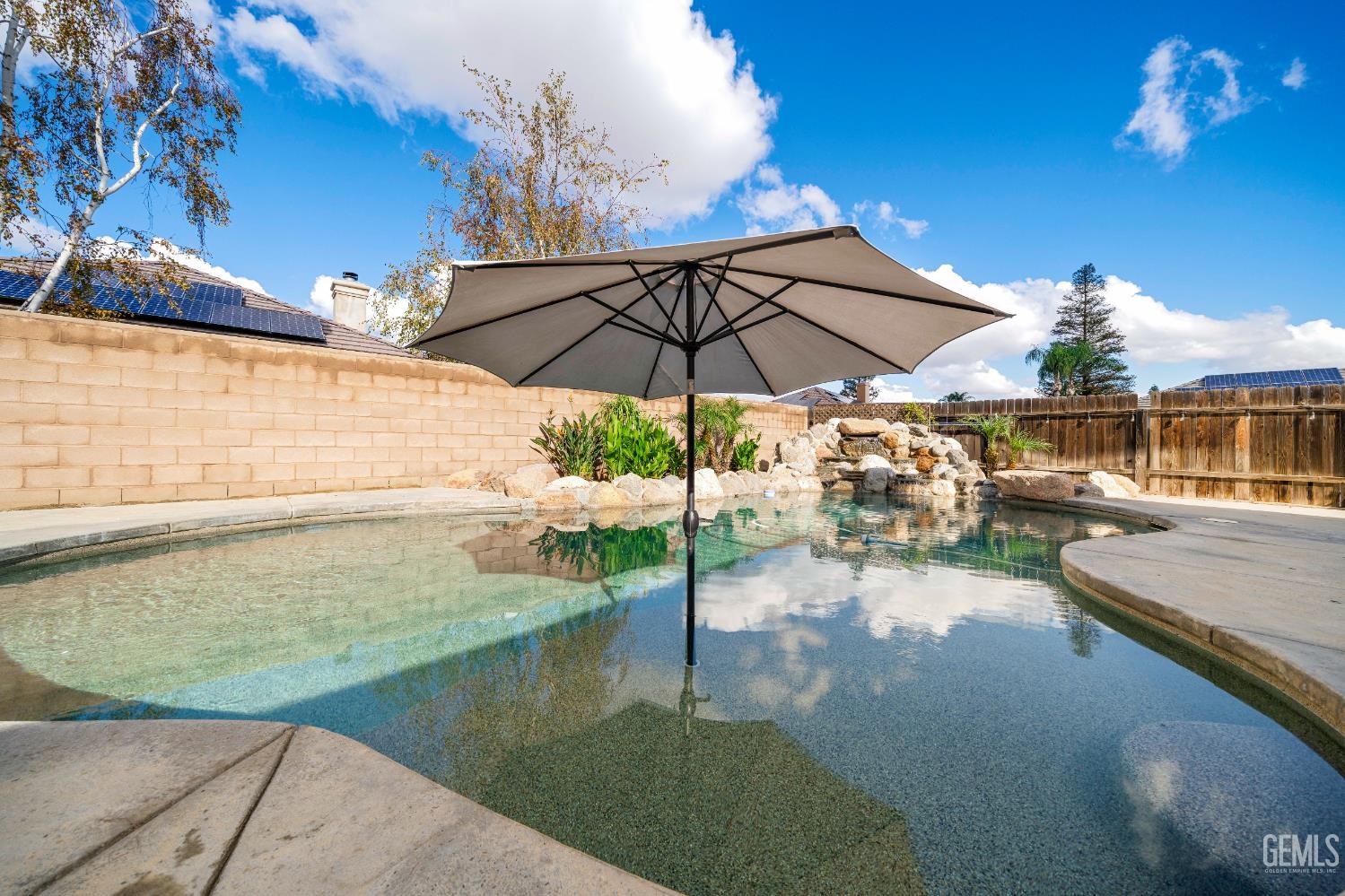 Backyard view of a Bakersfield pool home with waterfall feature in Shiloh Estates