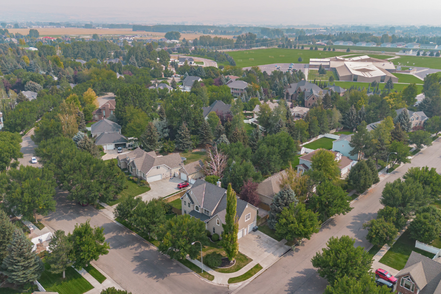 Aerial view of a tree-lined suburban neighborhood in Idaho Falls, Idaho, featuring established homes, quiet streets, and nearby community green space.