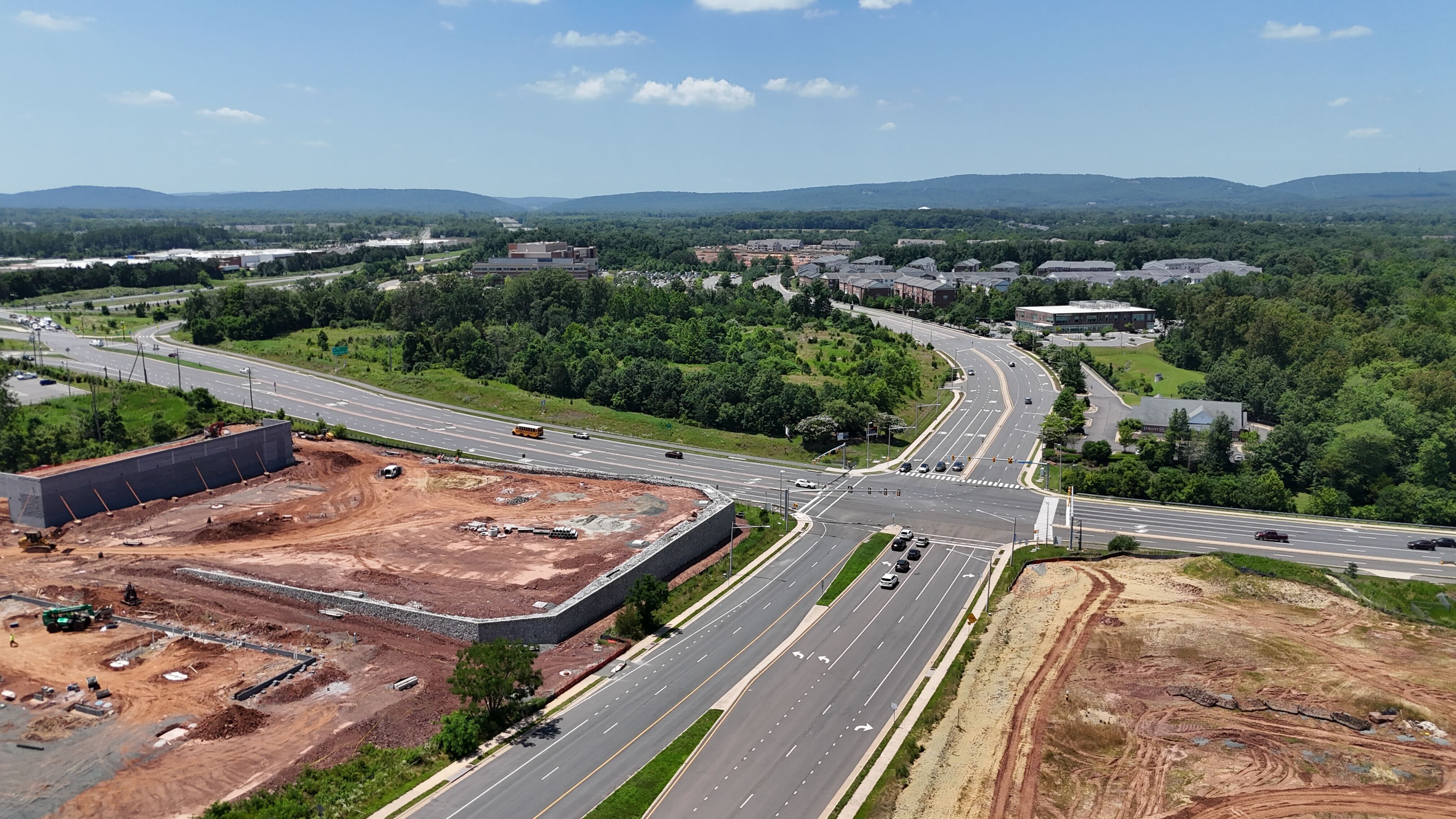 An aerial view of a construction site in Haymarket, Virginia, with the foundation laid, next to a major highway interchange.