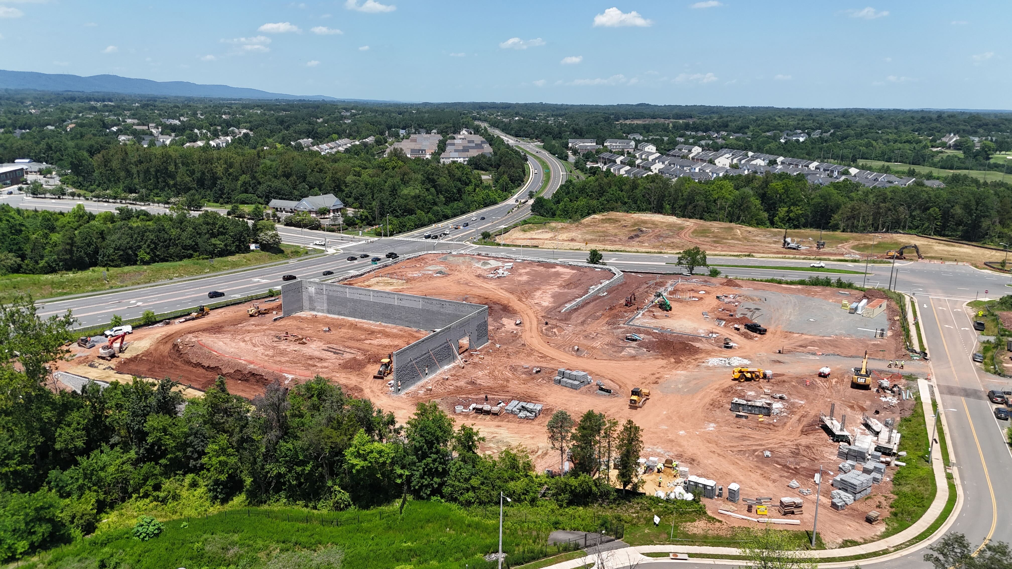 An aerial view of a construction site in Haymarket, VA, where the first concrete walls of a new building are being erected.
