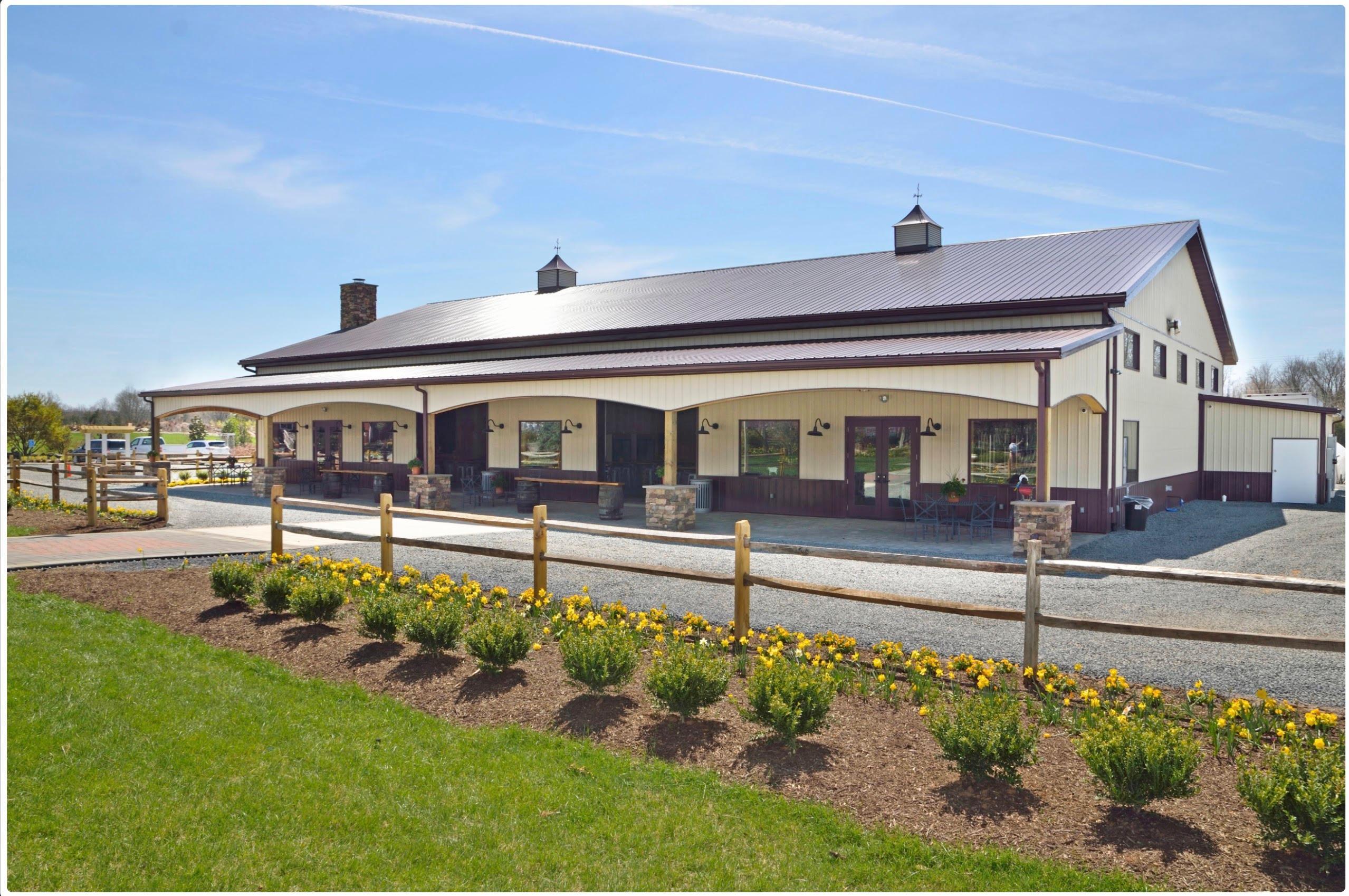The exterior of The Farm Brewery at Broad Run in Northern Virginia, featuring its welcoming building and spacious outdoor patio, ideal for summer movie nights and country events.