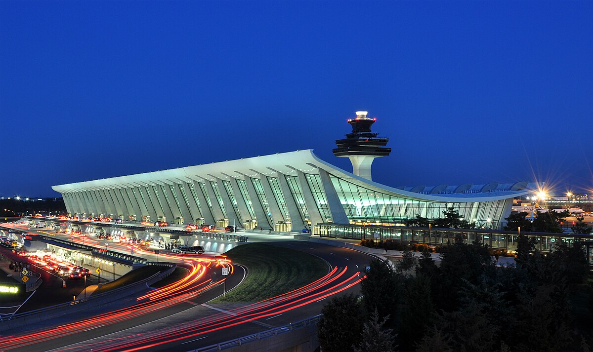 A wide view of the Washington Dulles International Airport terminal and control tower at dusk, showing the scale of the facility set to expand under the new Master Plan.