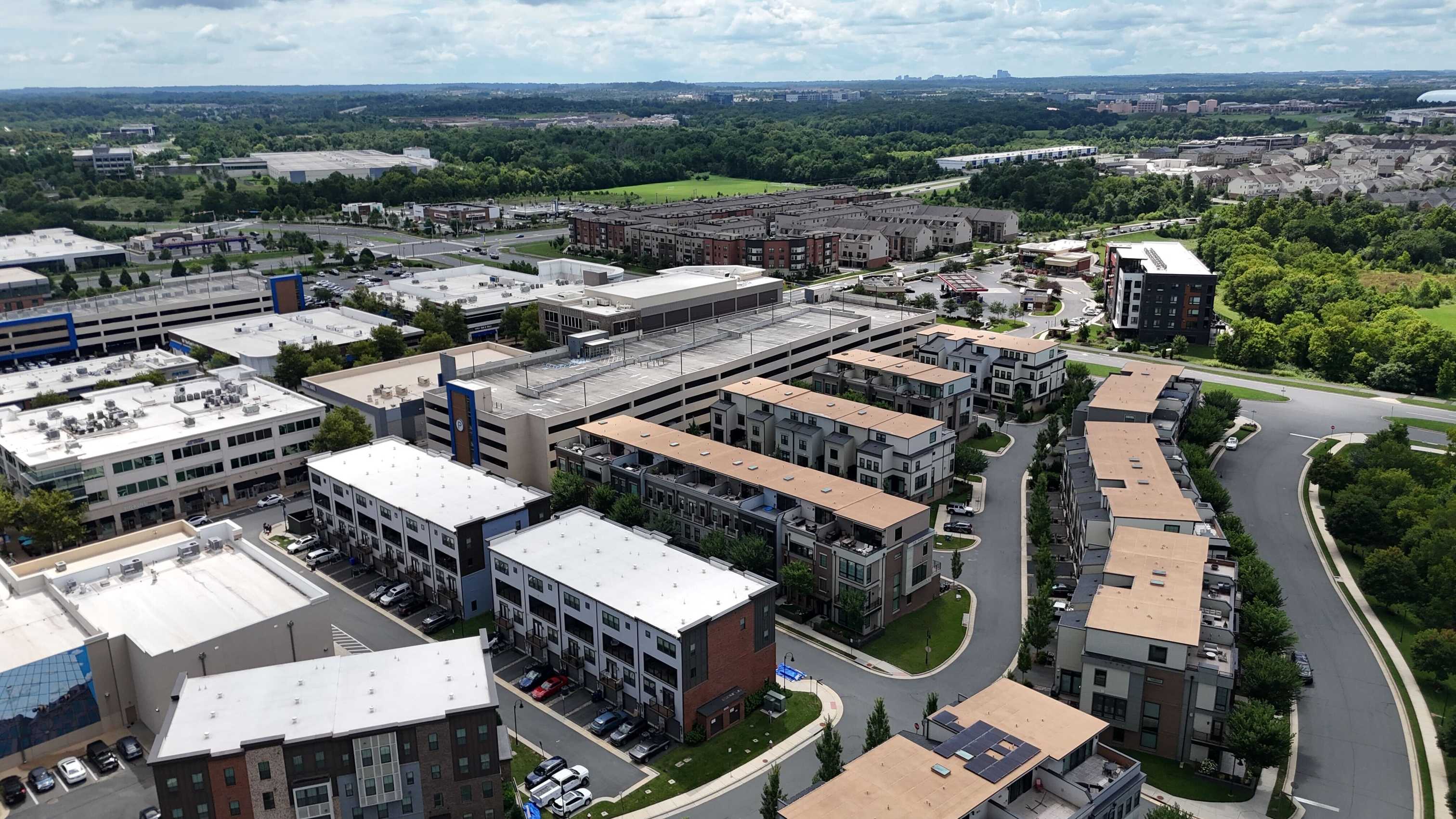 Real aerial photograph of One Loudoun townhomes and mixed-use development in Ashburn, Virginia; neighborhood context.