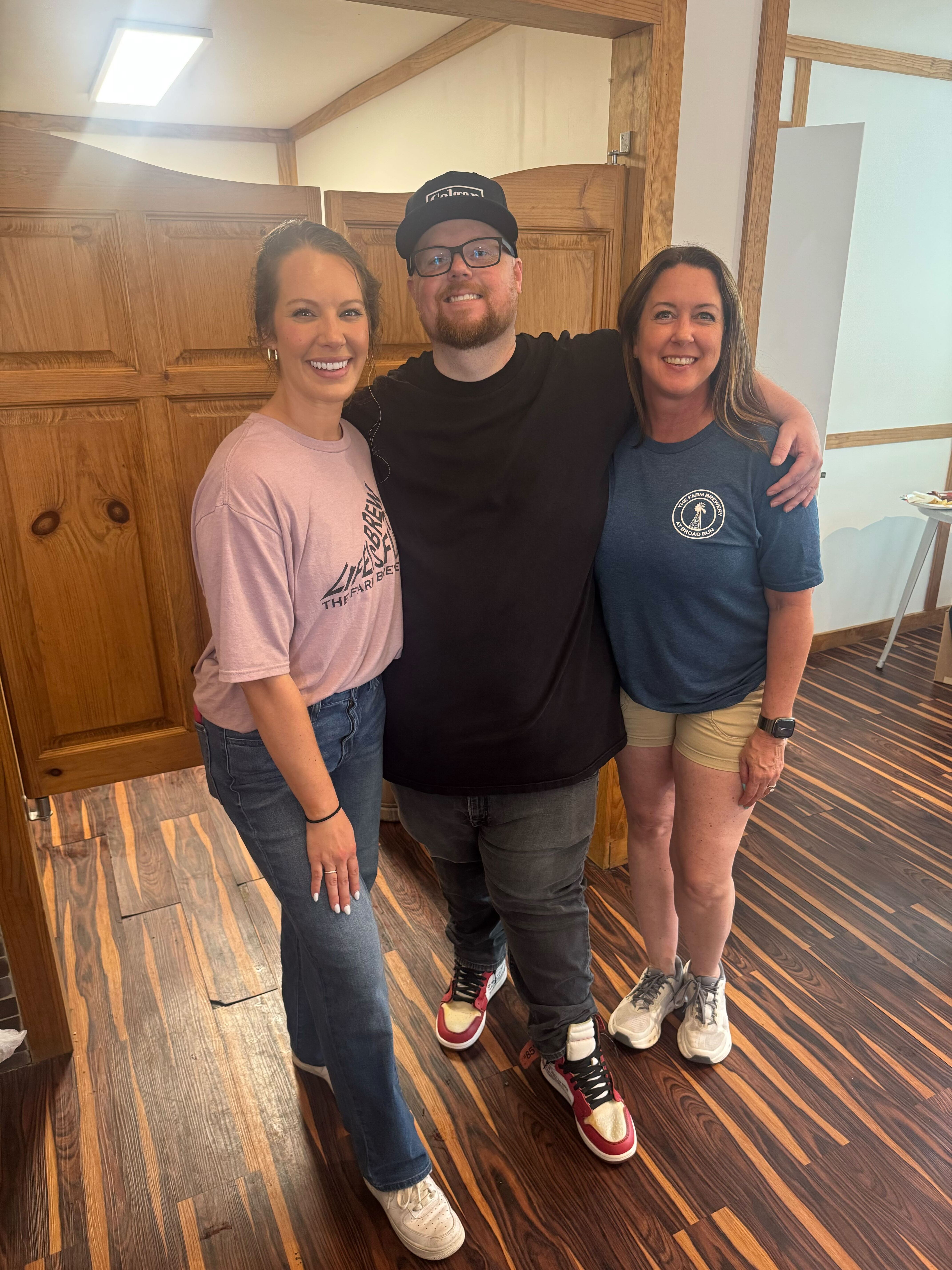 Realtor Chris Colgan posing for a photo with two staff members from The Roost at Farm Brewery during the Colgan Team client appreciation event.
